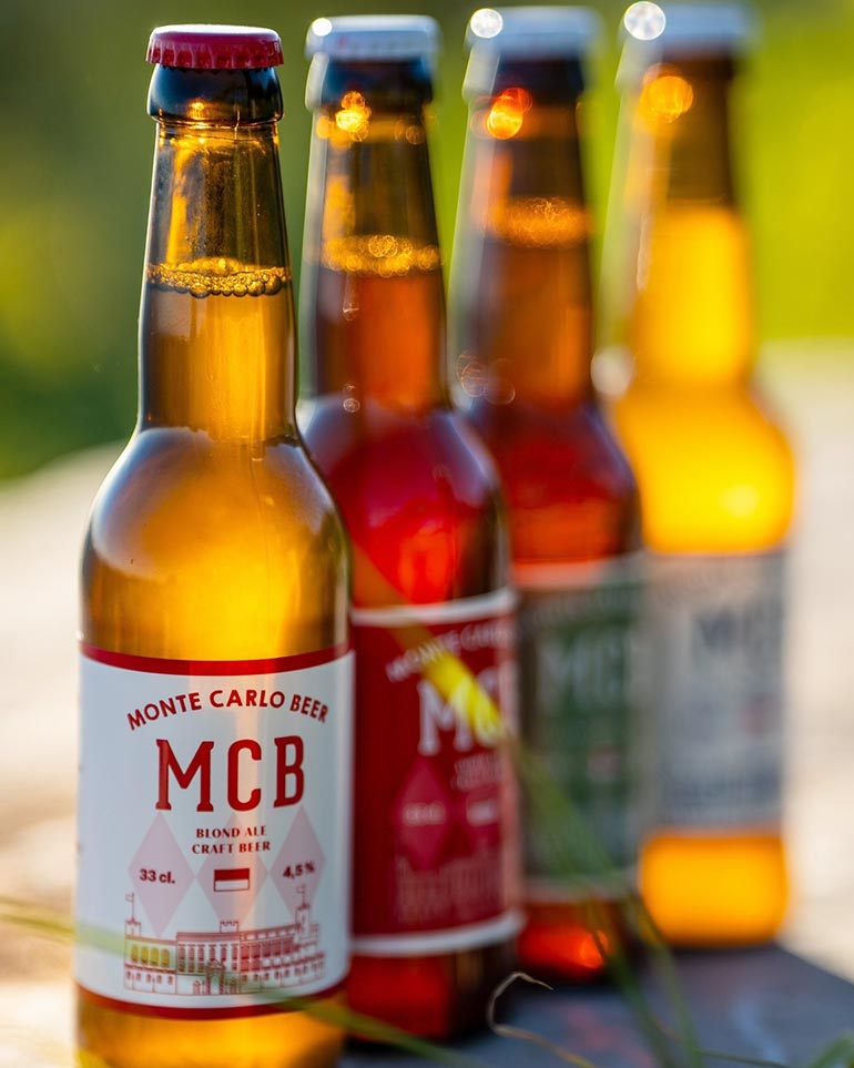 group of four monte carlo beer bottles outside during sunset