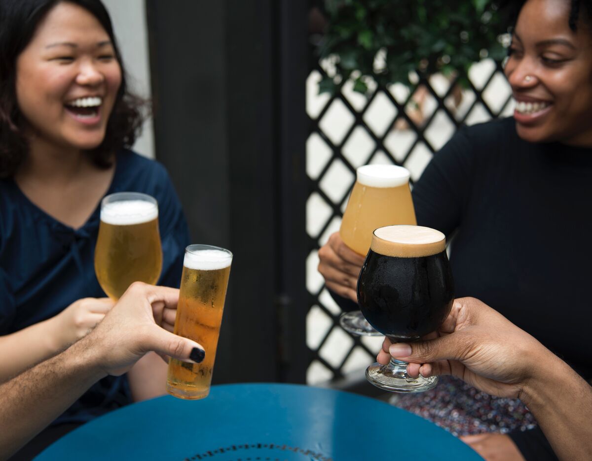 group of people clinking glasses outdoors at restaurant